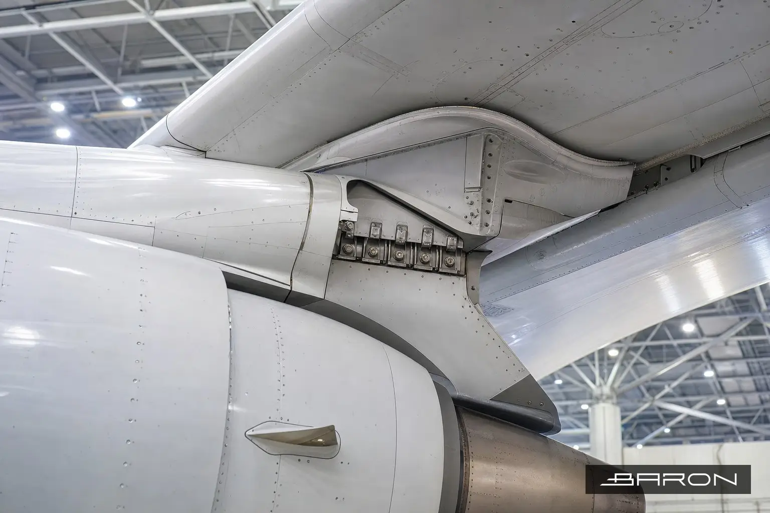 Commercial jet engine mounted on its wing pylon, the bolted attachment joint inspected by radiography